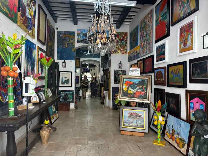 Art shop in Old San Juan with hundreds of colorful paintings on display in a beautiful light venue, with a chandelier in the ceiling