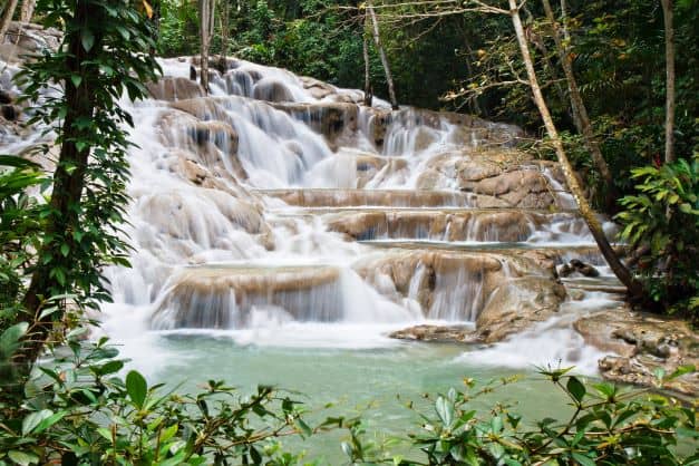 Dunns River Falls in Ocho Rios, a beautiful terraced waterfall where you can walk along it from the beach to the end 300 yards above.