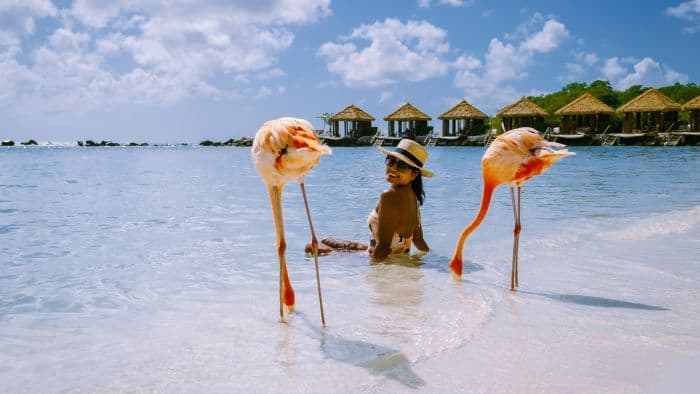 Solo female traveler on a white sandy sunny Caribbean beach. Travel Essentials For Women