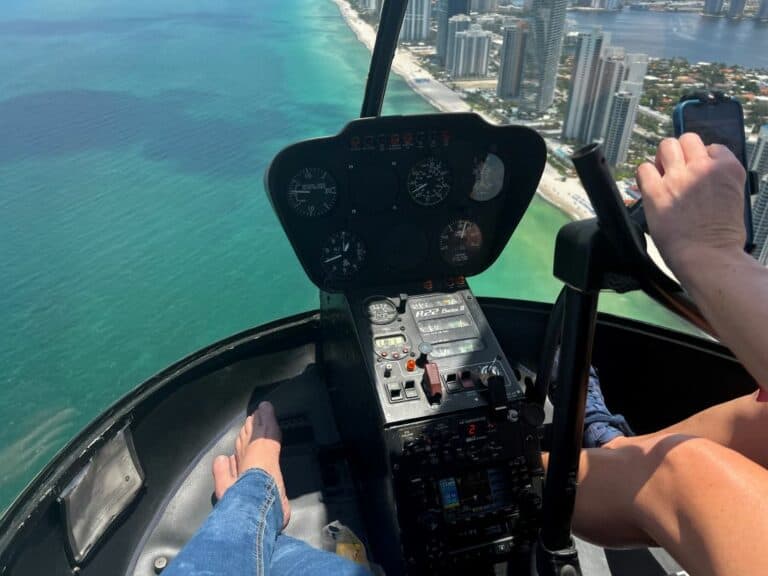 Private Helicopter Tour Fort Lauderdale. poking my feet out the open door flying over Miami Beach on a sunny day