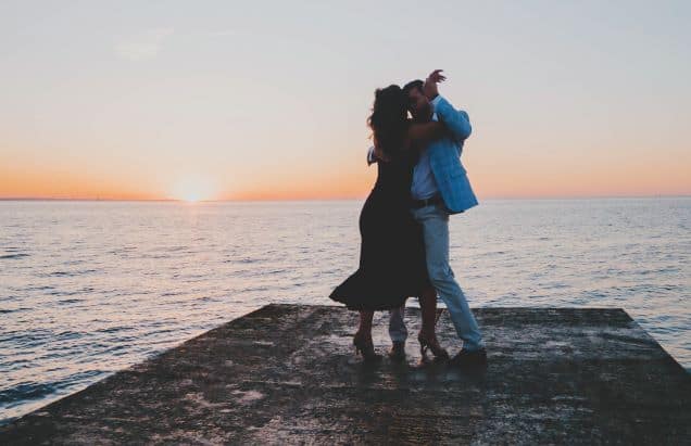Kizomba origin: couple dancing at the end of a pier during sunset.