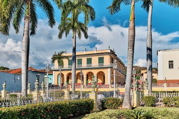 Best tours Trinidad Cuba: Palace Brunet Museum of Romance is a beautiful classic colonial building surrounded by a green lush garden with flowers and palm trees.