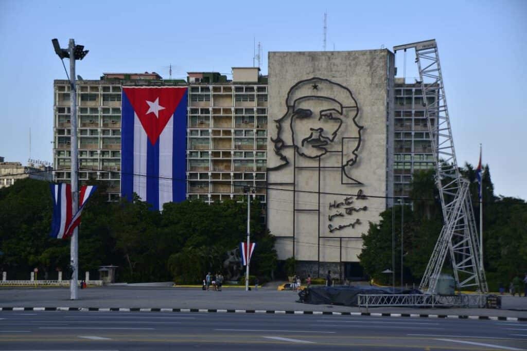 Plaza de la Revolucion in Havana, with the art piece of Che Guevara on a huge building next to the flag of Cuba