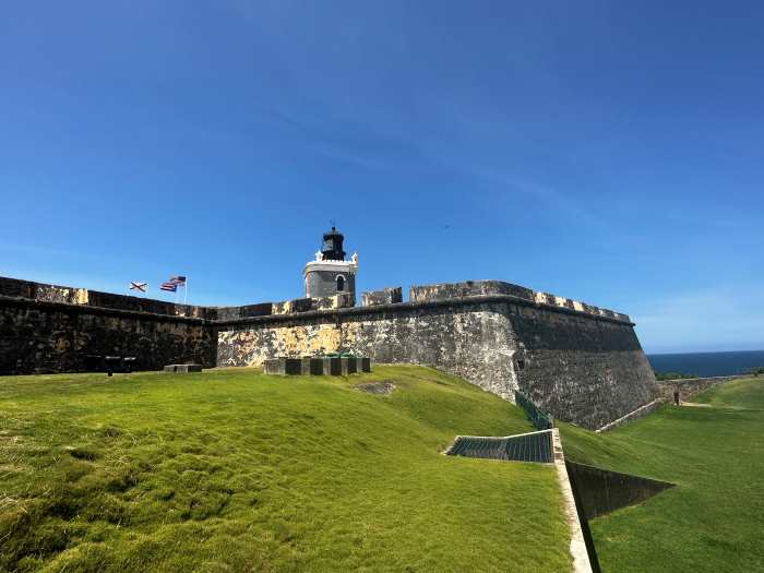 The old stone fortress on the tip of Old San Juan surrounded by fields of green grass on a sunny summer day