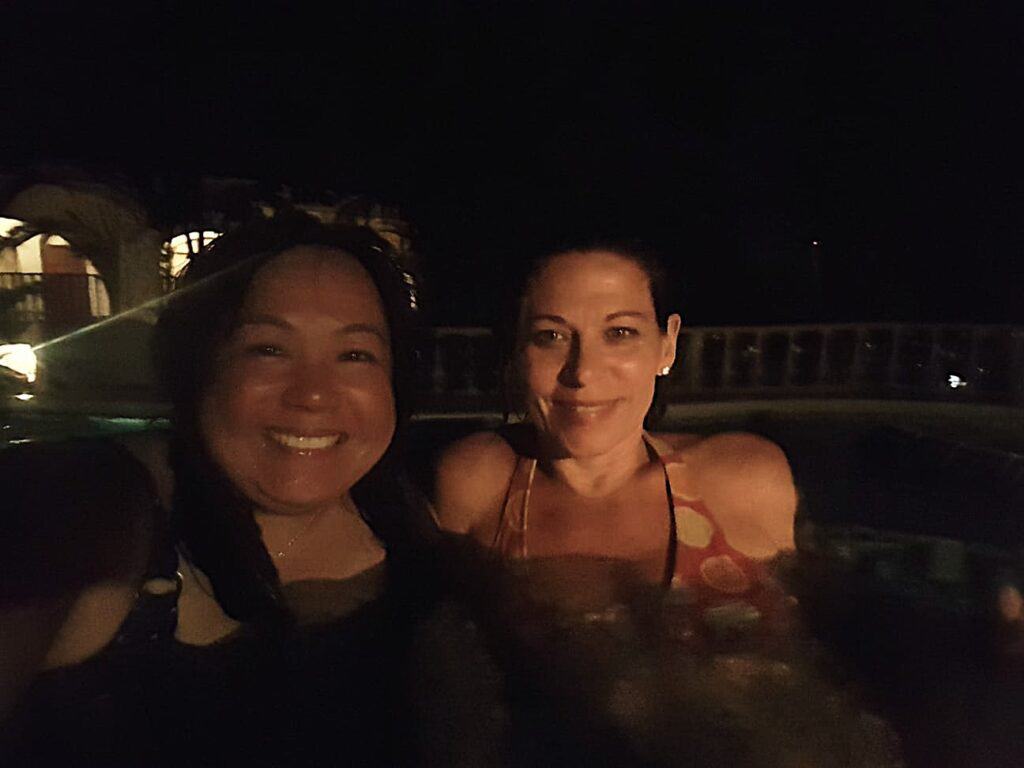 Two ladies in a hot spring on a Caribbean island at night