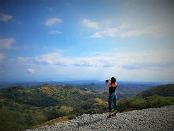 San Jose to Monteverde: how to travel between these two destinations in Costa Rica. Photo of the author at a lookout point just outside Monteverde with infinite views over the cenery to the ocean.