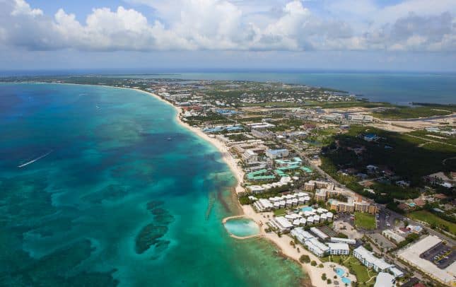 Aerial photo of Seven Mile Beach with scattered resorts along the West End of Grand Cayman
