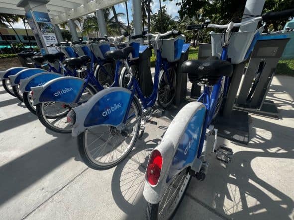 Blue and white city bikes on a rack in Miami on a sunny day