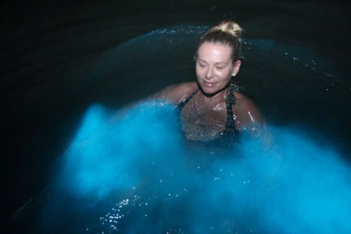 Swimming in bioluminescent water at night, the water turns bright blue around me when I move in the dark water