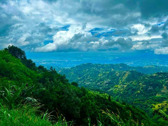 Incredible, green, infinite views of the Blue Mounains in Jamaica on a nice summer day with a bit of floating clouds in the sky
