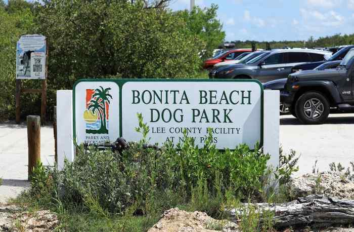 Bonita Beach dog friendly park; a white sign saying Bonita Beach Dog Park by the parking lot