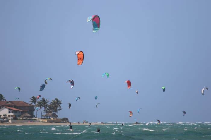 A myriad of kite surfers and kites in the air outside Cabarete Beach on the northern shores of the DR on a sunny summer day with blue skies over the water