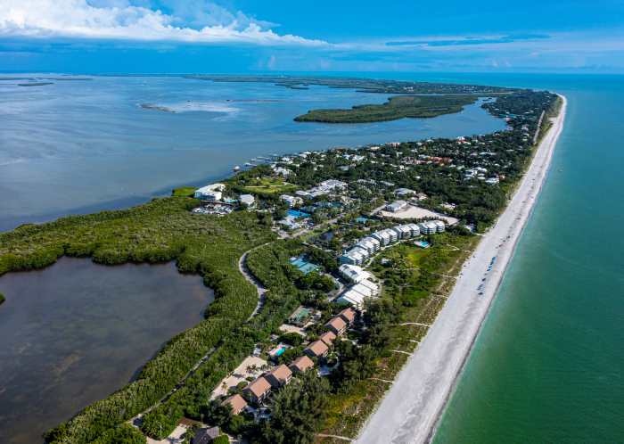 The long narrow Captiva Island from teh air, with a long stretch of white sands along the shore