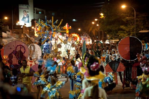 The carnival in Santiago de Cuba at night, with lots of dancers in sparkling costumes, lighs and life!