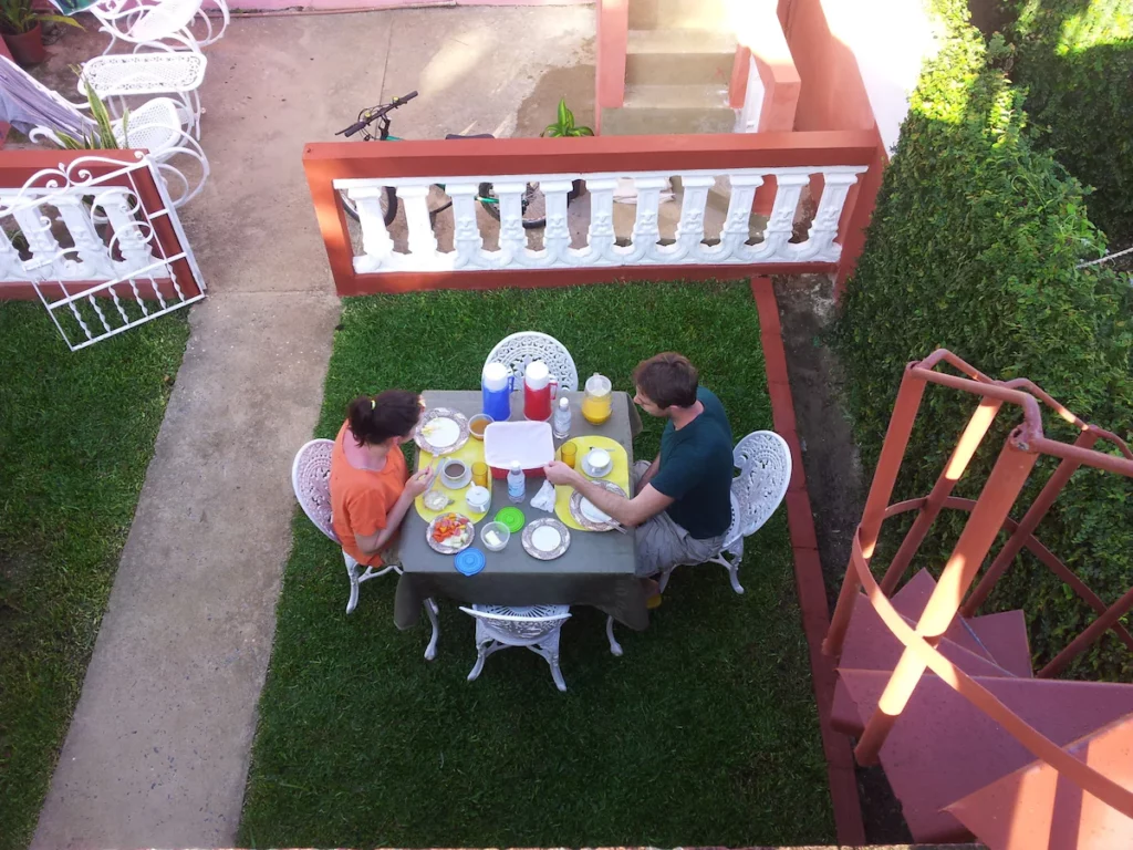 Cute breakfast table outside Casa Herenia y Pedro in Vinales, on the green grass in the small garden, inside the red and white fence on an early summer day. 