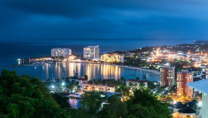 Beautiful photo of Ocho Rios at night with thousands of lights reflected in the water, and overview photo taken from the hills above the town. 