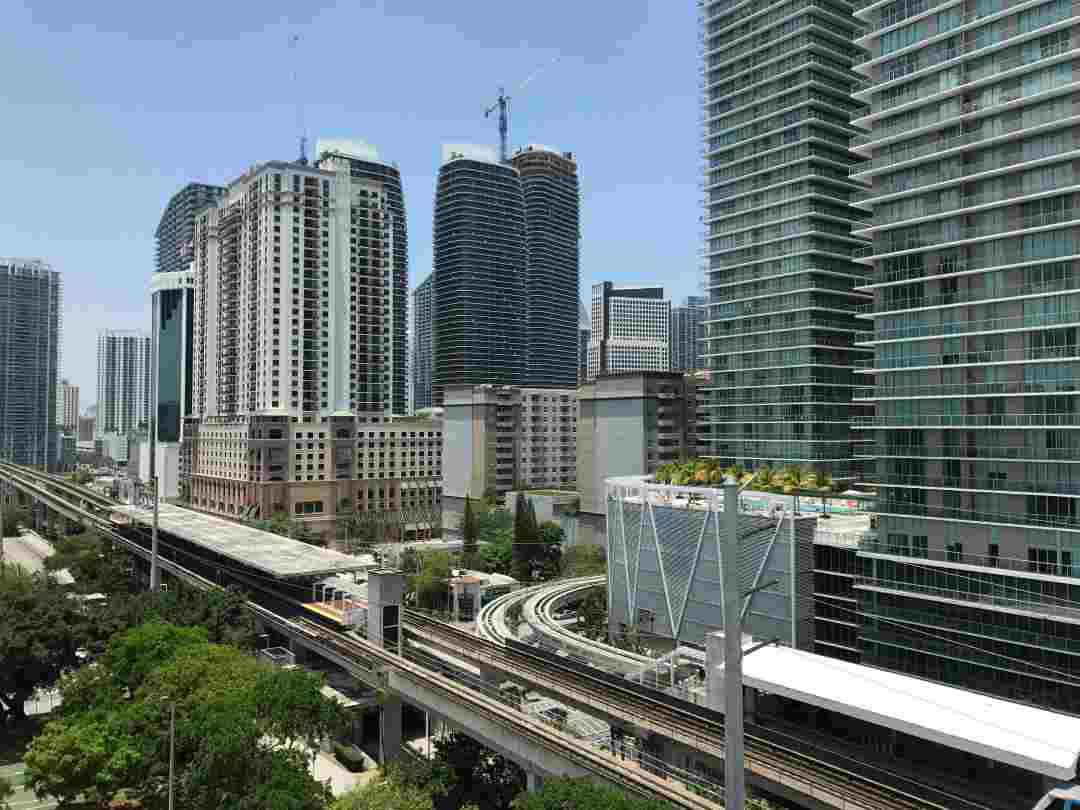 City scape of Downtown Miami; the modern highrises as a forest in the background, and the city train tracks in the foreground on a sunny day