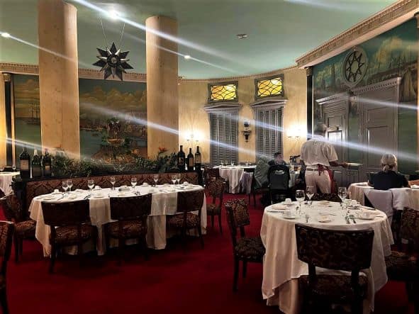 The inner part of the Floridita where you find the restaurant has thick red carpets, tables with white table cloths, thick elegant columns, and large pieces of art paintings on the wall. 
