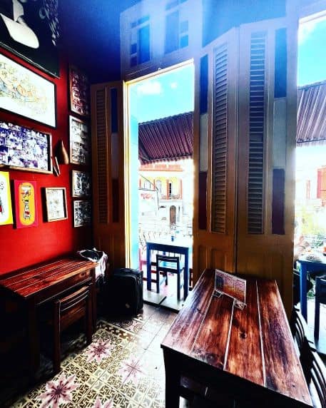 Dark wood interior at the Loco Loco paladar, colorful decorated tiles, an the high windows where daylight comes in from the balcony. 