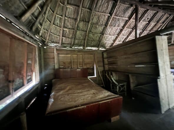Fidel Castros dark and gloomy bedroom with a large bed under wooden ceilings in Commandancia de la Plata, the hidden HQ in Sierra Maestra where he hid in the 50s. 