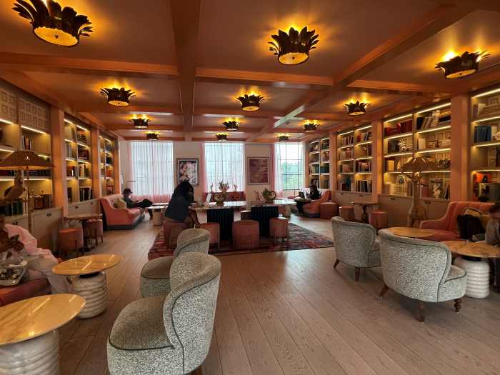The elegant and charming library at the Goodtime Hotel in South Beach with warm lighting and seating zones amidst lots of book shelves