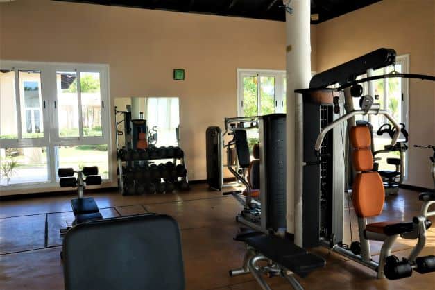 Fresh gym in a varadero resort with lots of equipment, while the sun sifts through thewindows from the beautiful gardens outside. 
