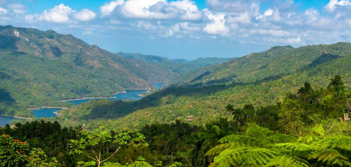 Escambray Mountains and National Park, with blue water on hte bottom of the wide valley, and green hills on all sides into infinity. 