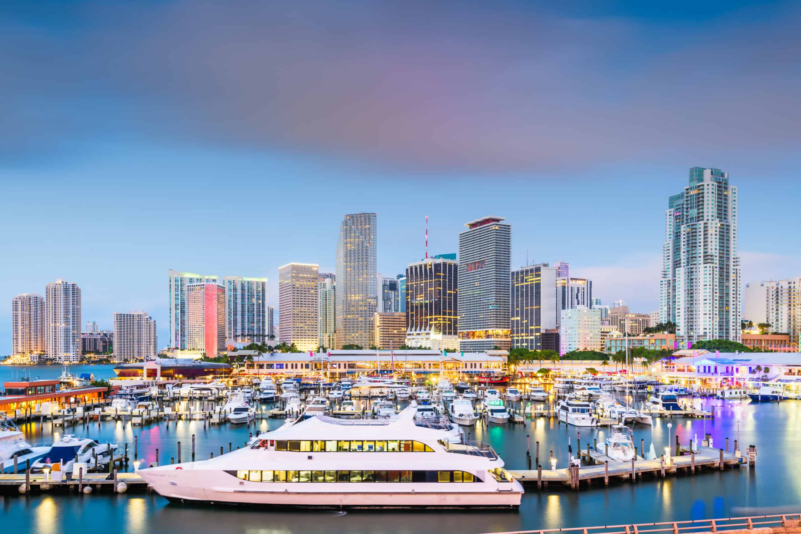 Yachts and day cruises in a large port in Miami with the skyline in the background