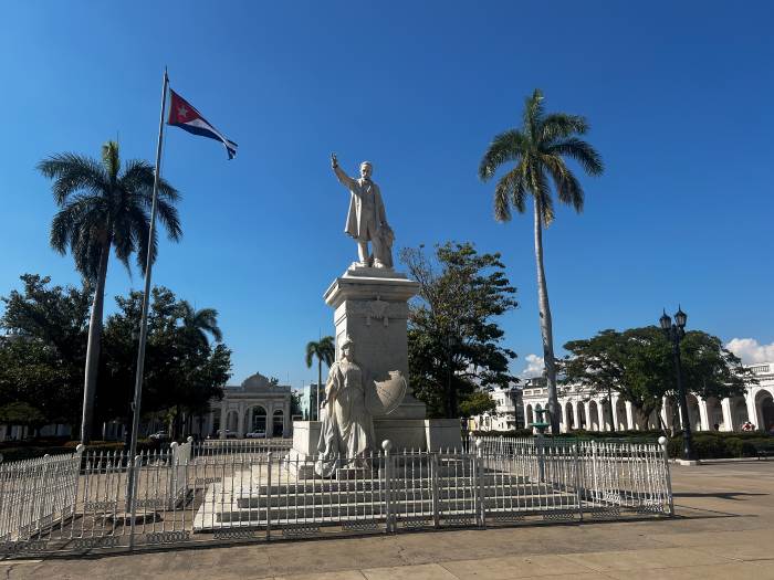 The statue of Jose Marti in Cienfuegos largest square in Cuba on a bright summer day with blue skies, and palm trees scattered around the square