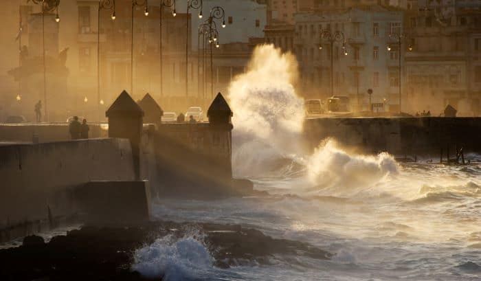 Waves hitting the Malecon in Havana at night, white foam roaring