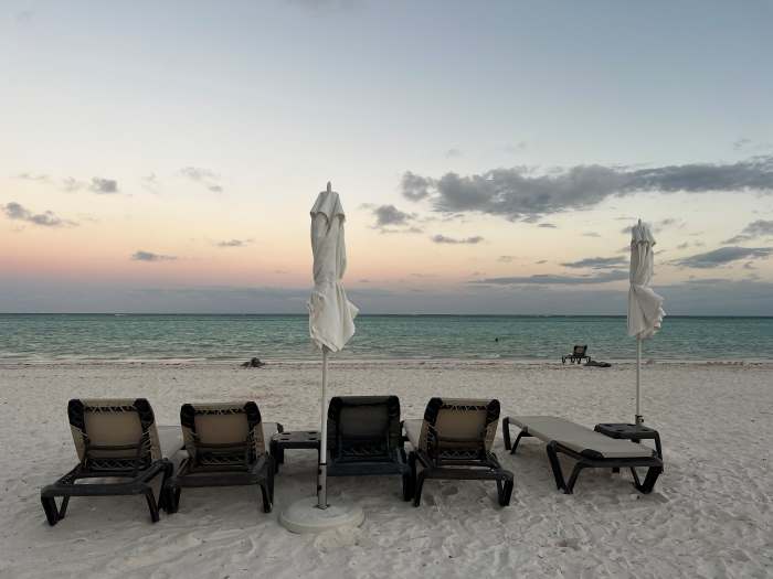 Sun loungers on the Hyatt Zilara beach right after sunset with beautiful pale skies, green ocean, and white sands