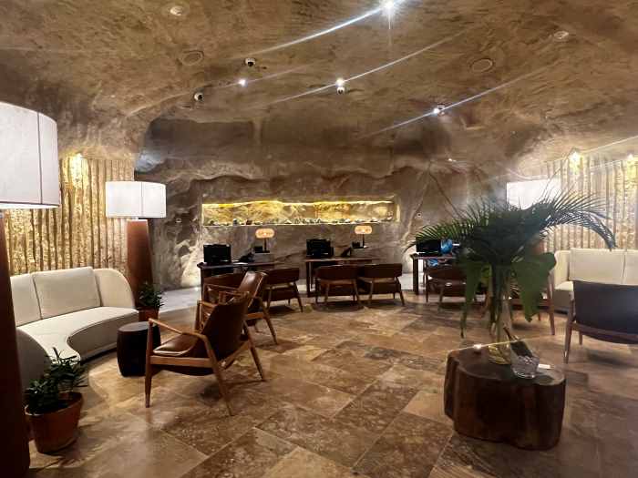 The elegant spa foyer is in an artificial cave, and the inside looks like the inside of a cave! With white sofas, elegant chairs, beautiful tiles on the floor, green plants, and warm lights, this is a tranquil space. 