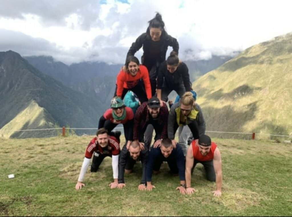 Traveling solo does not mean traveling alone. From my Inca Trail trek in Peru where me and my group made a human pyramid, in front of a vast green valley with mountains on each side. 