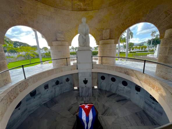 The elegant mausoleum of Jose Marti in Santiago de Cuba, where Marti is buried under the Cuban flag in a circular dome with columns in white stone and marble. 