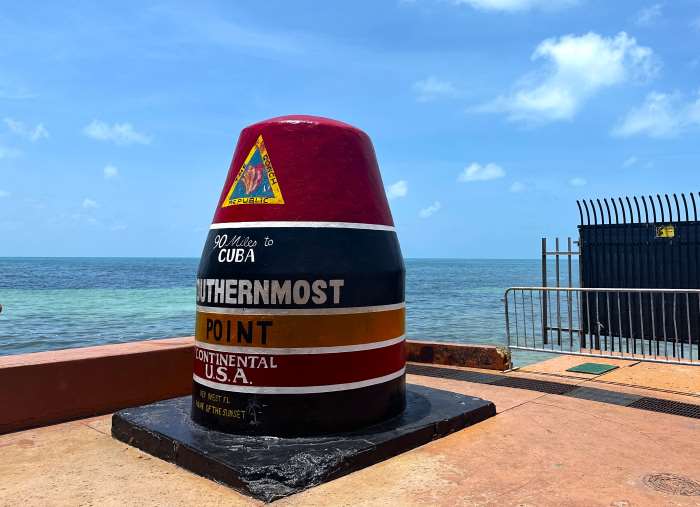 The red bouy that marks the southernmost point in the US in Key West, with the blue sea in the background