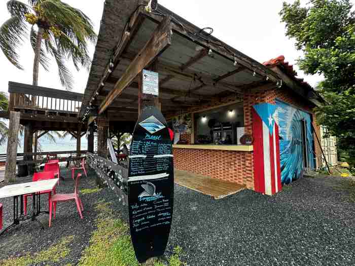 The little surfe bar by the lighthouse in Rincon, with the menu printed on a surf board, and the bar has colorful details and simple outdoor seating