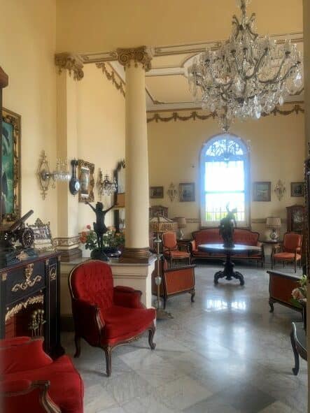 Elegant rooms in La Villa Teresa with glass chandelier, rococco furniture, and elaborate columns and art details. 