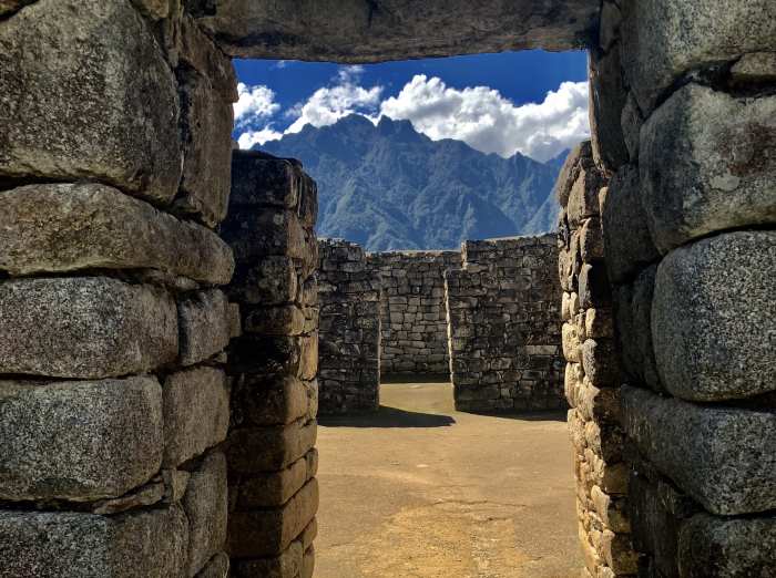 Exploring the ruins in Machu Picchu, the stone walls and houses, some without roofs like here. 