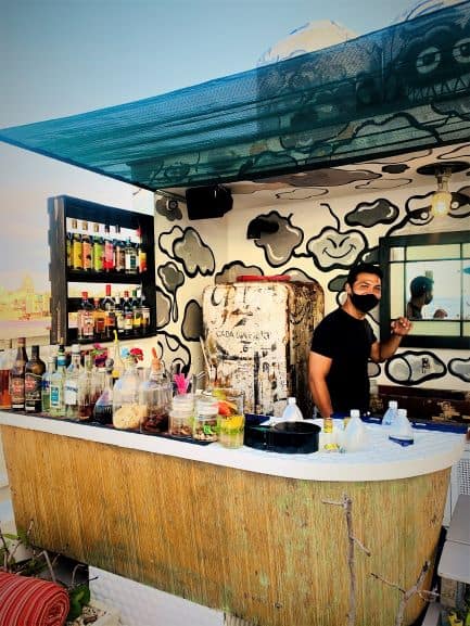 Malecon 663 bar with colorful wall art and happy bartenders. 