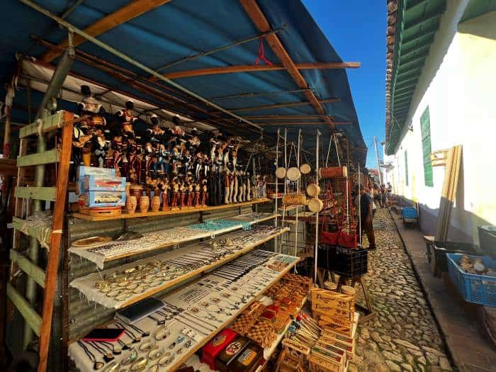 Stands in a cobblestoned market street in Trinidad, with artifacts for sale