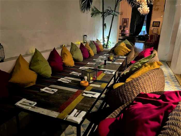 Charming and inviting seating area at Paladar Mischifu in Central Havana, with lots of colorful pillows along the long table. 