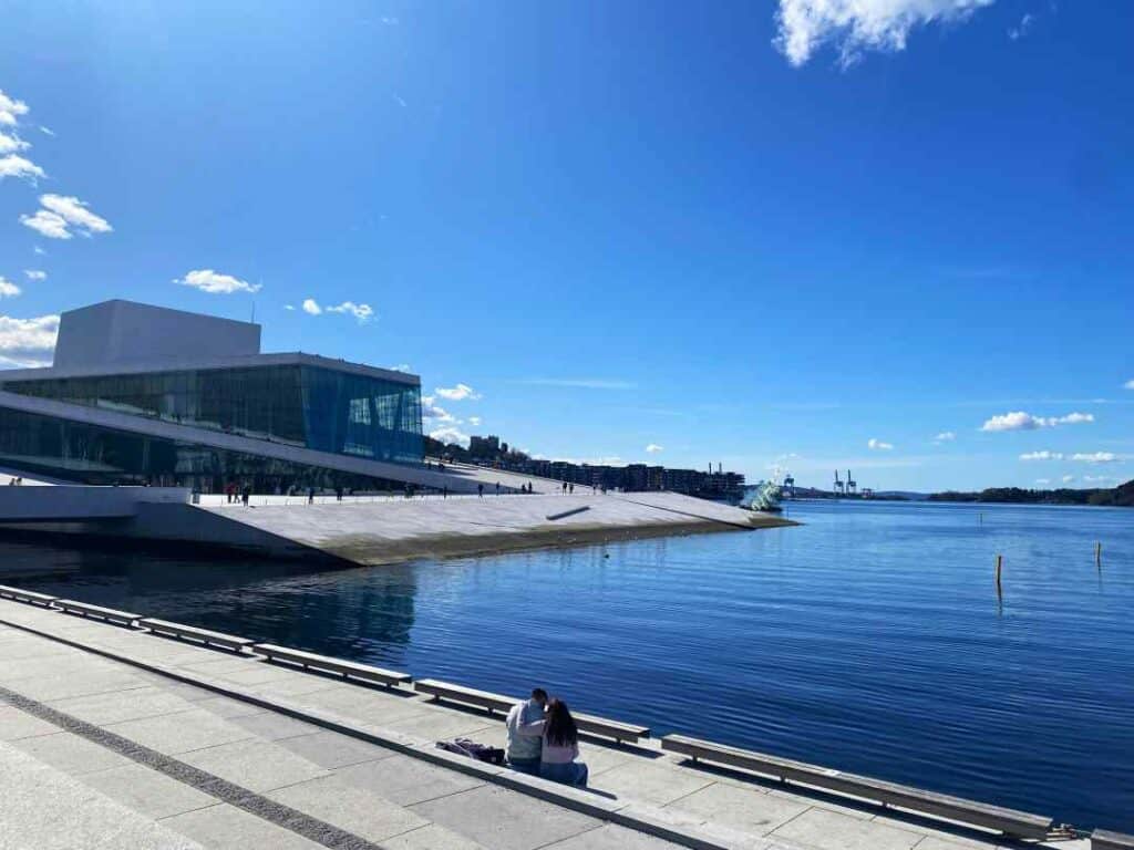 The Opera house in Oslo center, shaped like a white glacier sliding into the fjord on a bright sunny day
