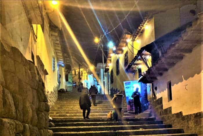 Steep streets in Cusco with stairs at night between the stone houses, in golden light