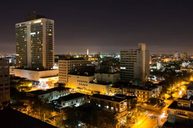 Overview photo of the Vedado neighborhood in Havana at night, the streets with warm golden lighting, and you see the lights of the city stretching out for miles
