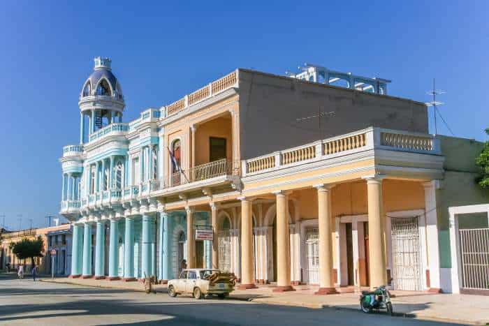 Palacio de Ferrer in Cienfuegos, in baby blue with the famous corner tower where you can keep watch of the city, against a backdrop of a clear blue sky. 