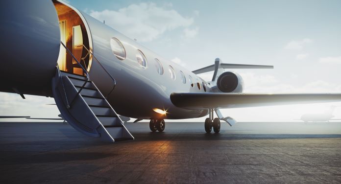 A small white plane standing on an airport with the door open and stairs ready for someone to step in