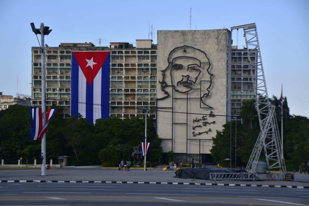 Plaza de la Revolucion in Havana, where there is a large art sketch of Che Guevara covering an entire building adjacent to the revolutionary square next to a huge Cuban flag.