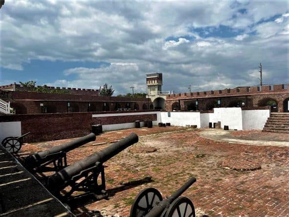 Inside the fortress Port Royal, all maroon brick structures, some are painted wihte, and there are a lot of old cannons along the walls