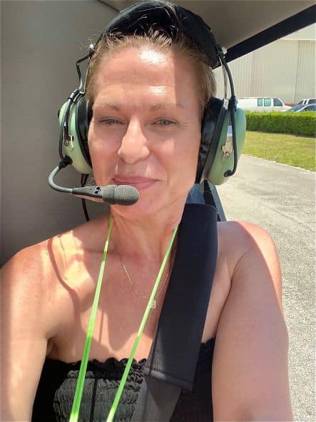 Me taking a selfie in the helicopter right before take-off, smiling, with the headset on still on the tarmac