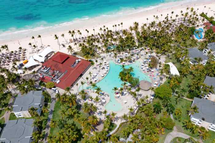 Aerial photo of resorts along Bavaro Beach Punta Cana with palm trees, pools, and the white sands of the beach with blue waters outside